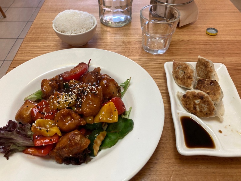 A sweet and sour curry with soy nuggets and capsicum. A side plate of dumplings